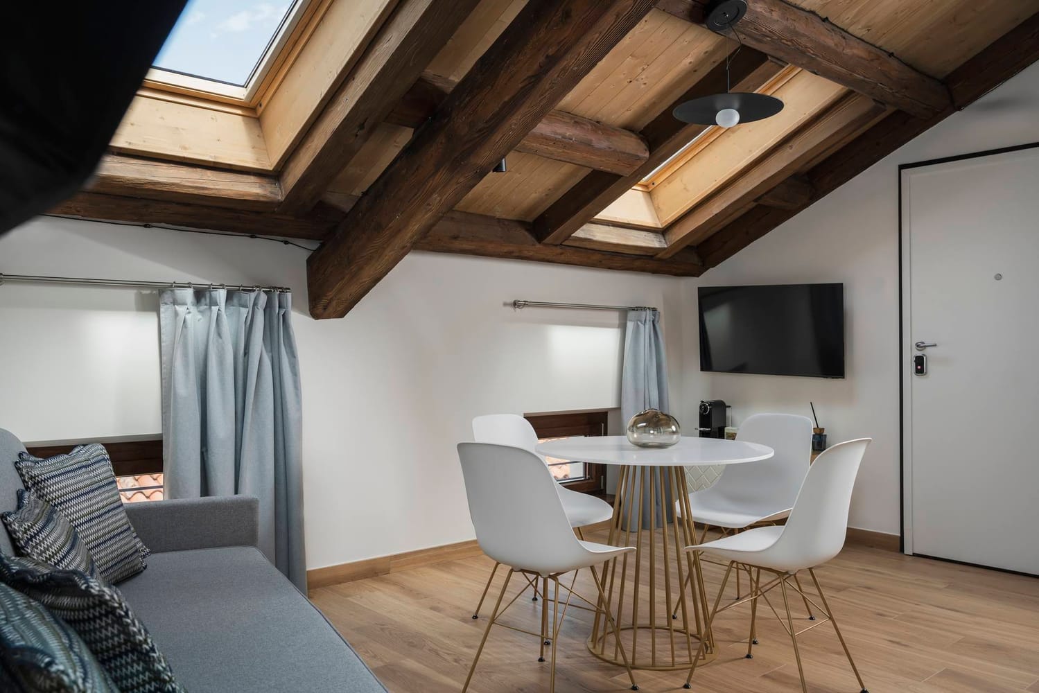 Detail of the living area with sofa and dining table in the Standard Apartment