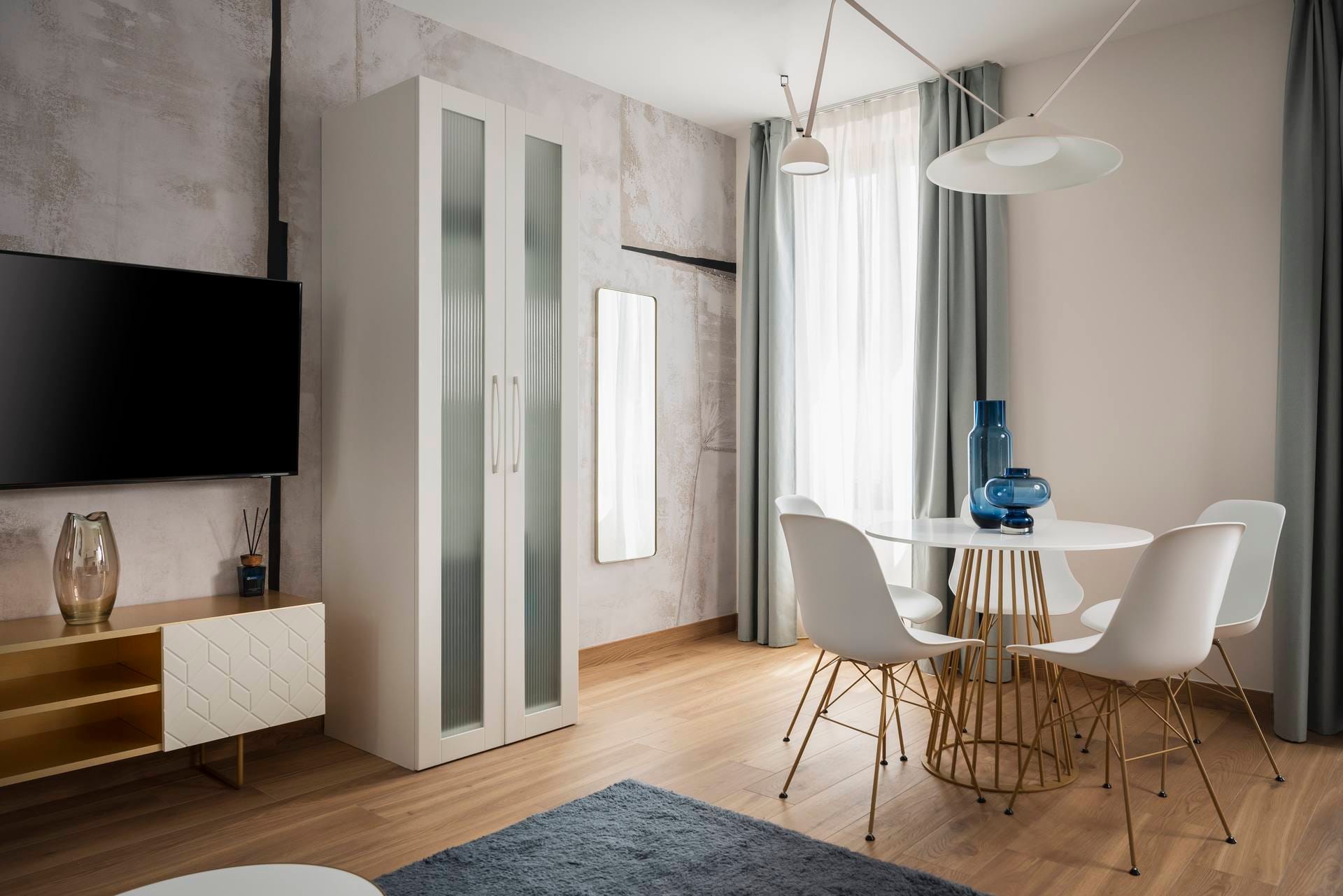 Detail of living area with dining table and flat-screen TV, Superior Apartment with Canal View