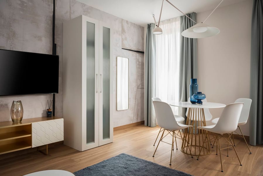 Detail of living area with dining table and flat-screen TV, Superior Apartment with Canal View