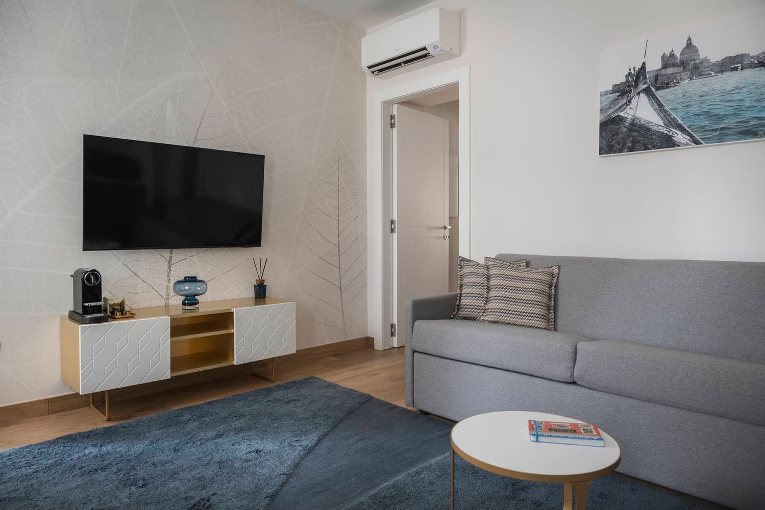 Detail of living area with sofa, flat-screen TV, and split air conditioner, Classic Apartment with canal view