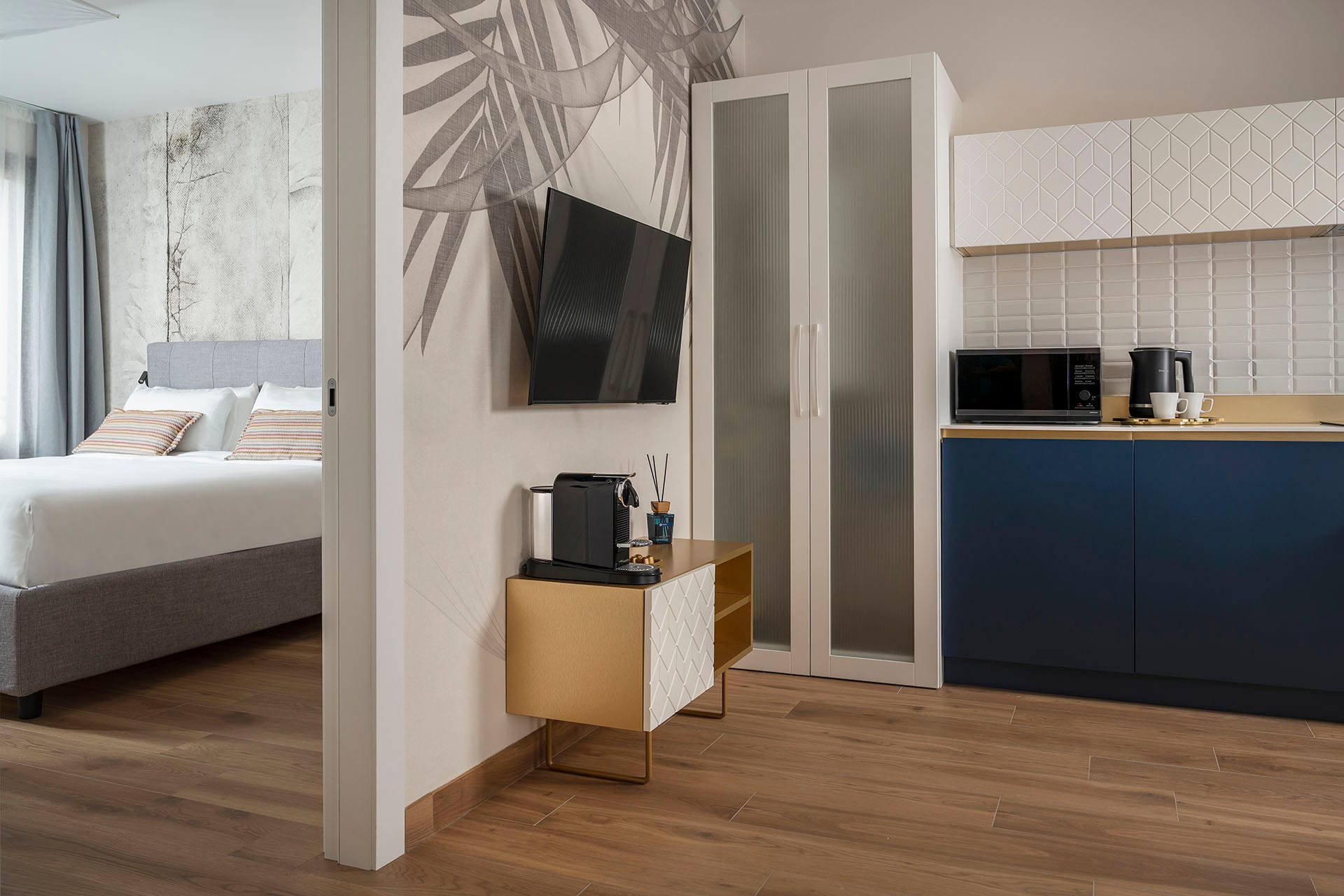 Living area detail with fully equipped kitchen, TV, and coffee machine in the Classic Apartment