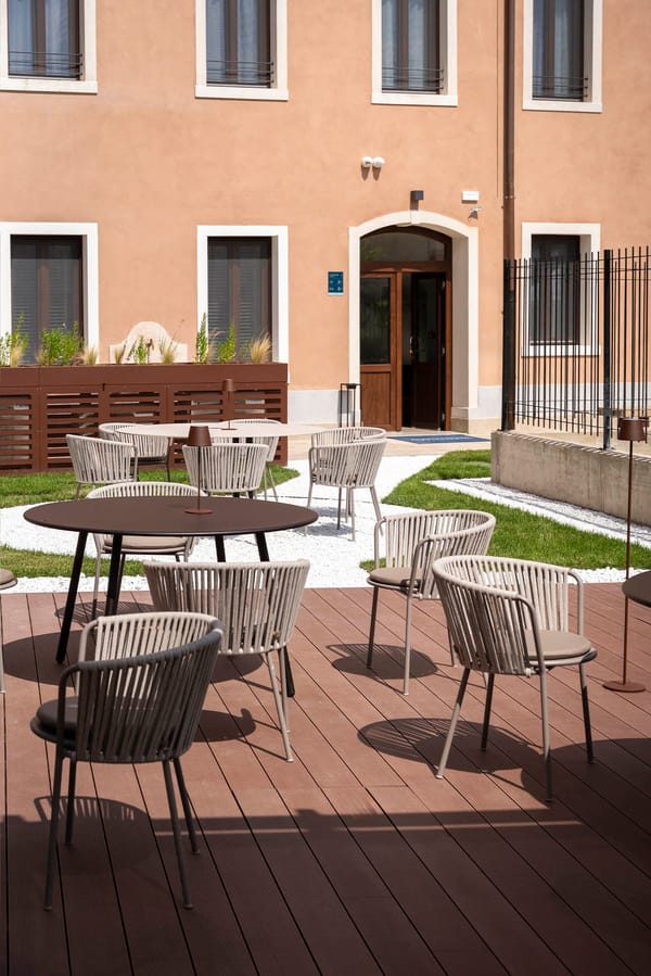 Outdoor garden furnished with armchairs and tables at the Palazzo dei Guardiani, Venice