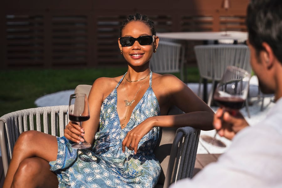 A young woman in sunglasses enjoying a glass of wine in the hotel garden