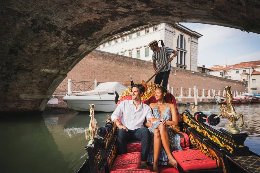 Young people on a gondola tour through the canals of Venice