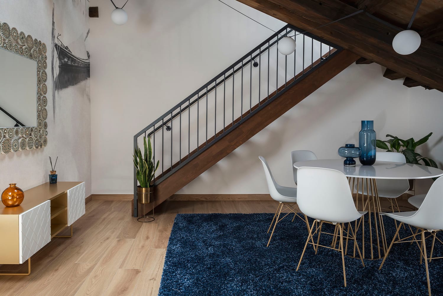 Living area with dining table and stairs leading to the second floor in the Executive Apartment, Palazzo dei Guardiani