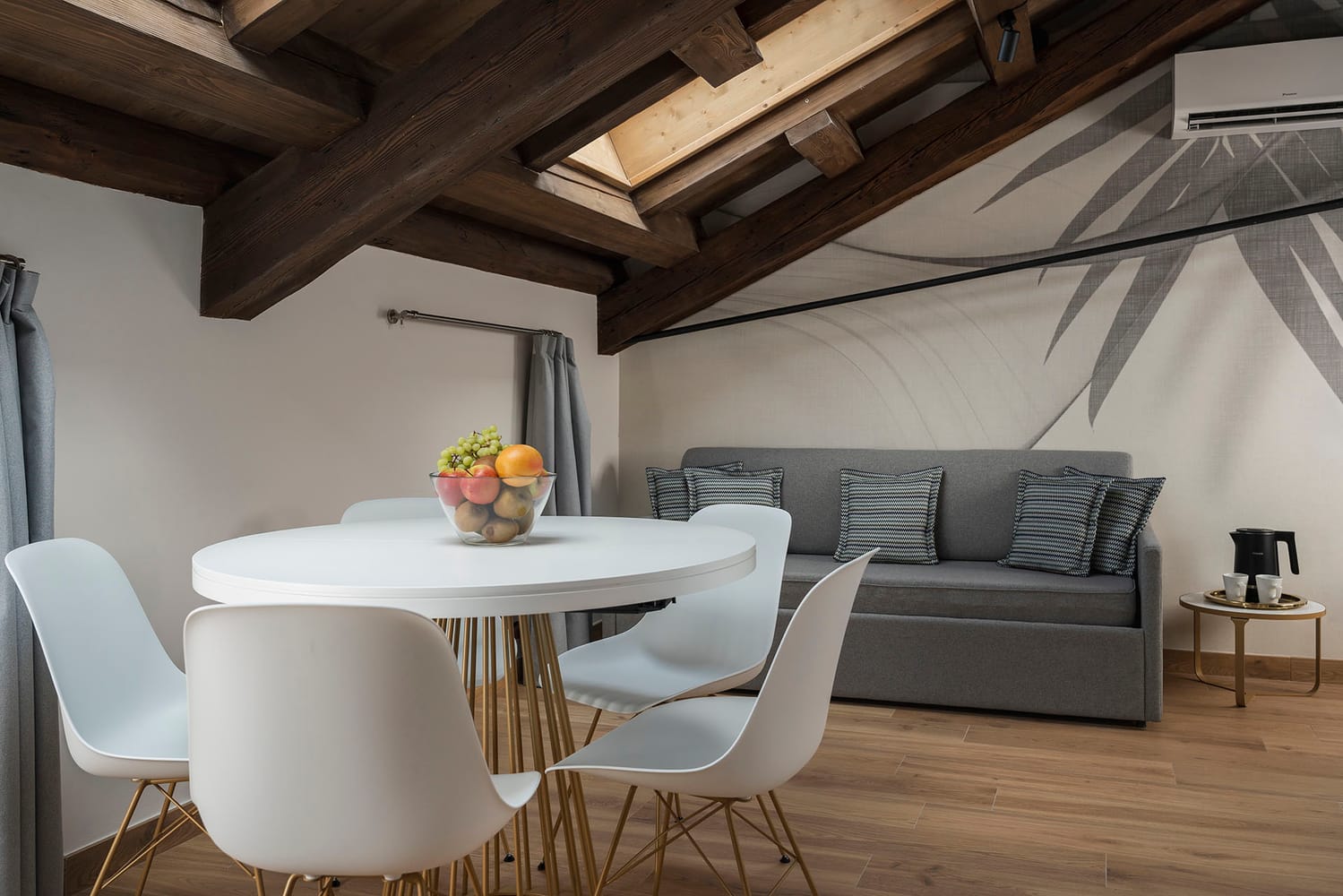 Detail of living area with exposed beam ceiling, sofa, and dining table, Comfort Apartment, Palazzo dei Guardiani, Venice