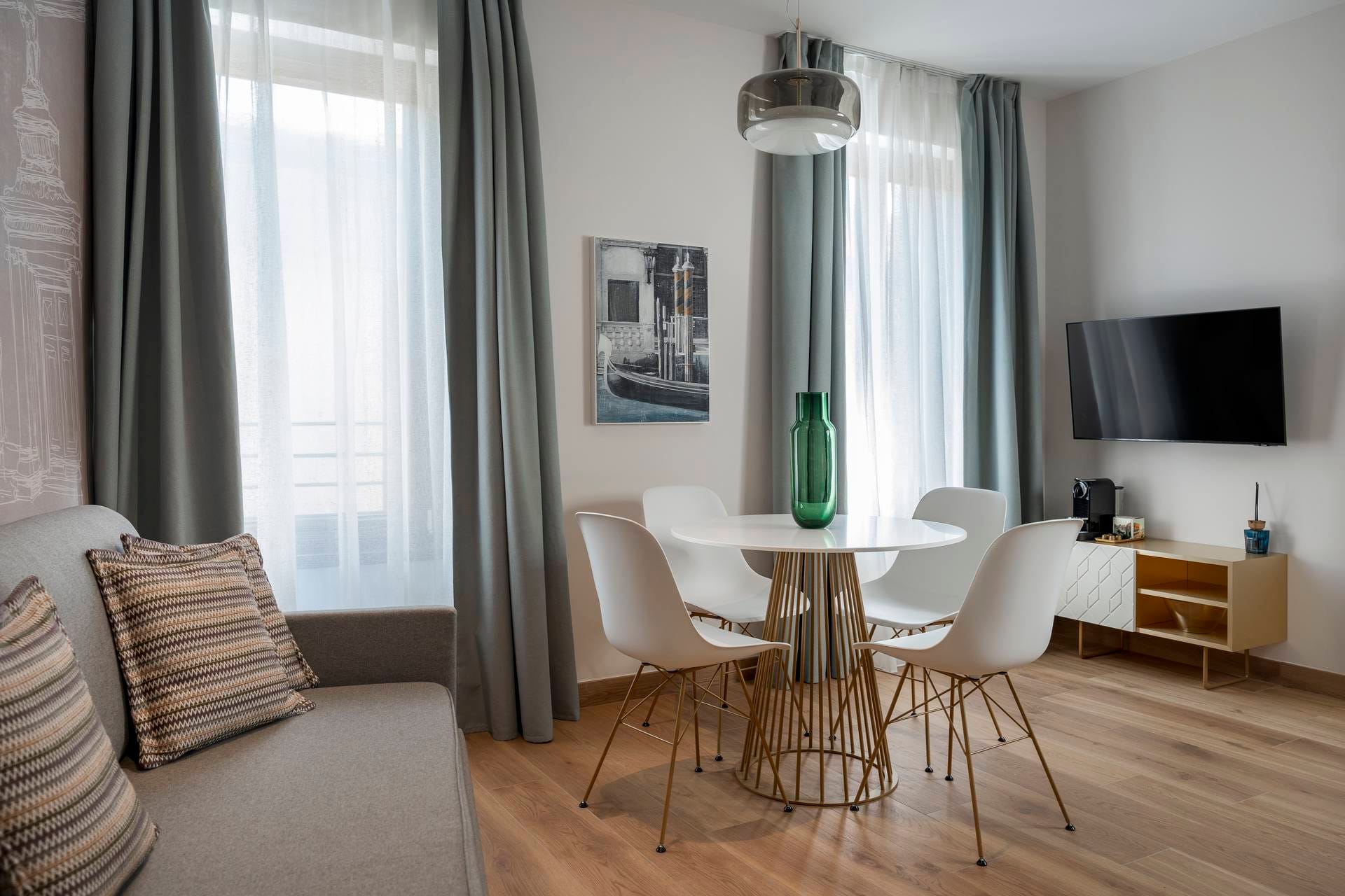 Detail of living area with sofa, dining table, and flat-screen TV, Classic Apartment with canal view