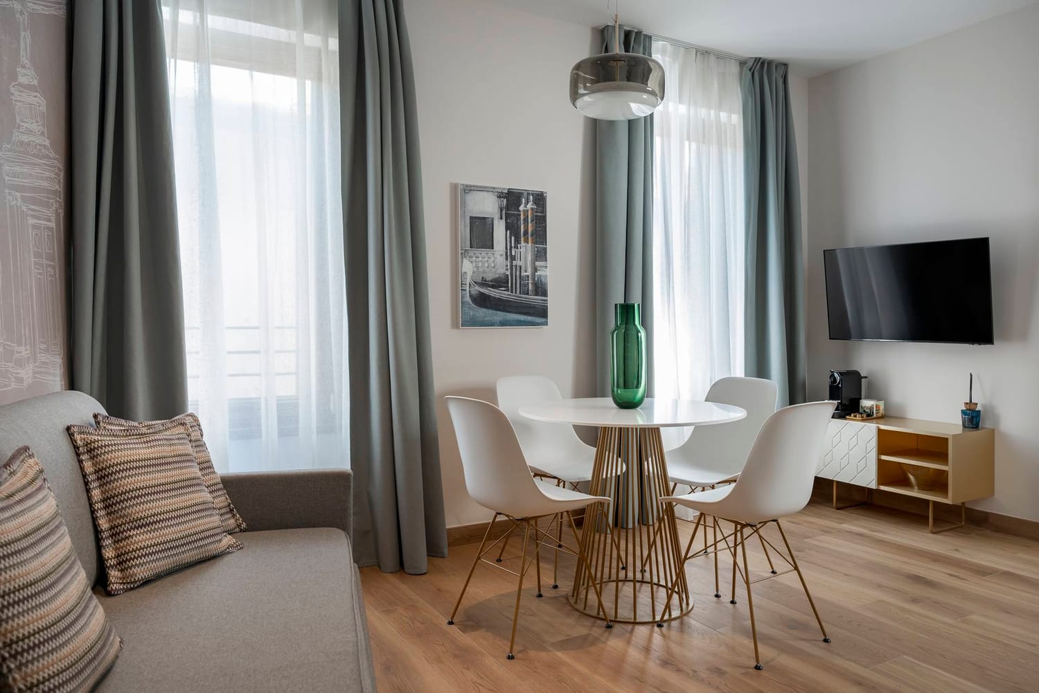 Detail of living area with sofa, dining table, and flat-screen TV, Classic Apartment with canal view