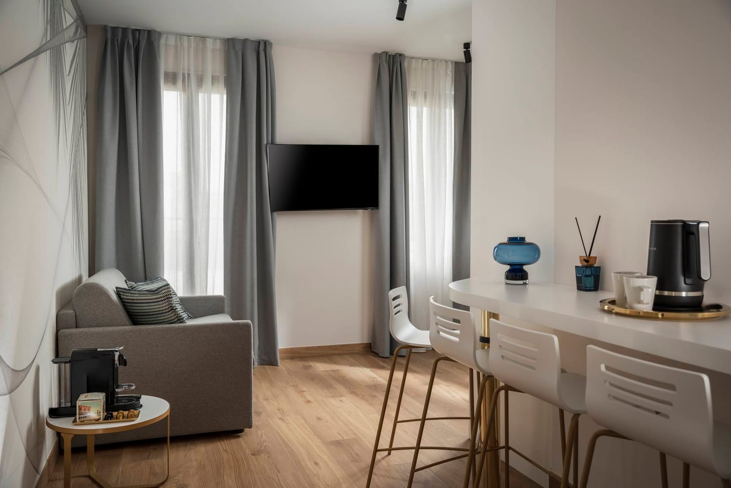 Detail of living area with sofa and breakfast bar with stools, Comfort Apartment