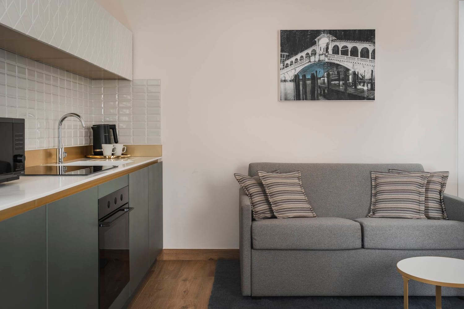 Detail of living area with sofa and fully equipped kitchen, Superior Apartment with Canal View